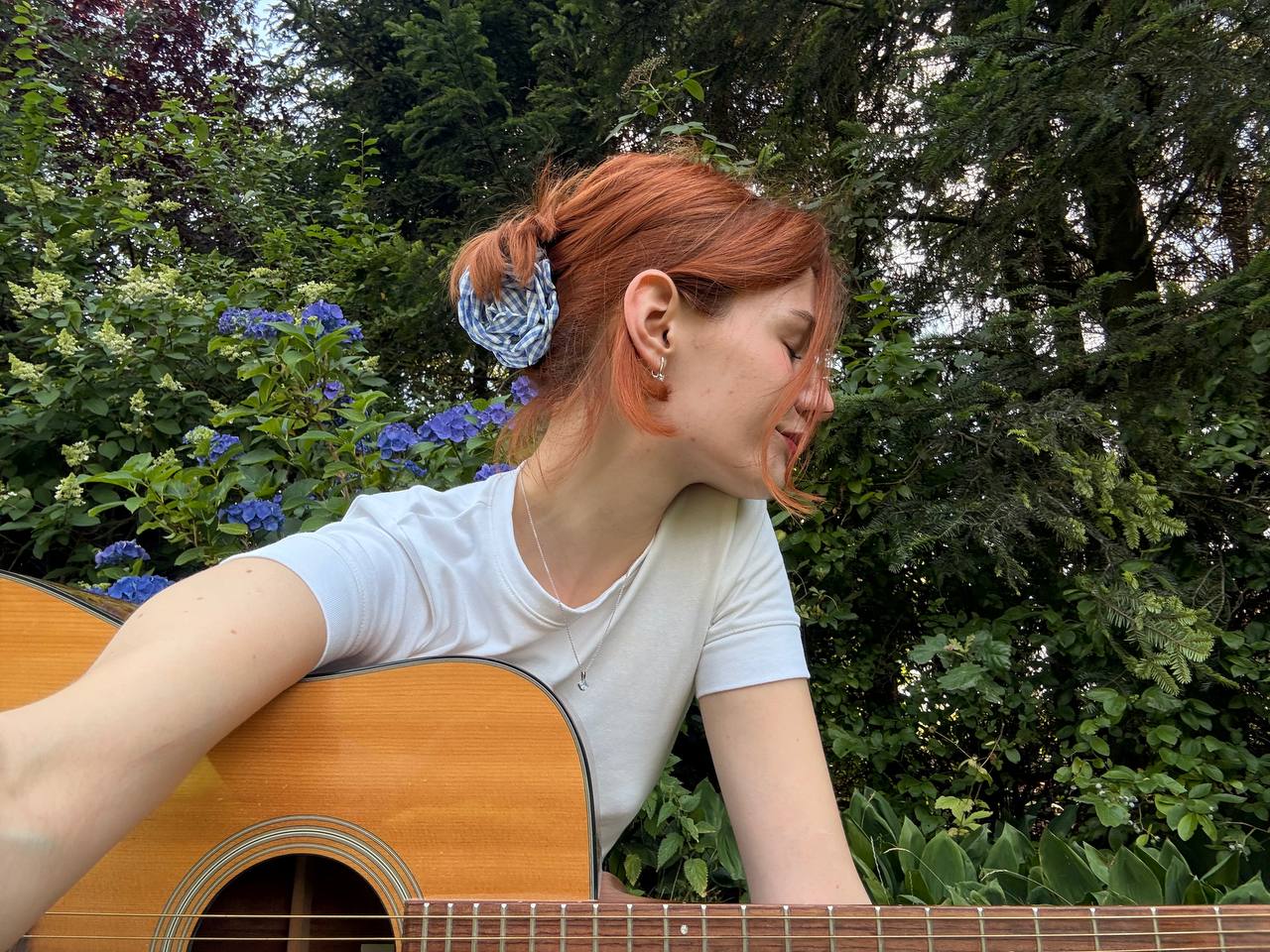 Mira Taylor with her acoustic guitar in the garden